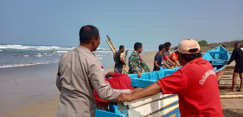 Bhabinkamtibmas Polsek Cikeusik Bantu Evakuasi Perahu Nelayan Binuangen yang Terdampar di Pesisir Pantai Kp Talanca 1 pc